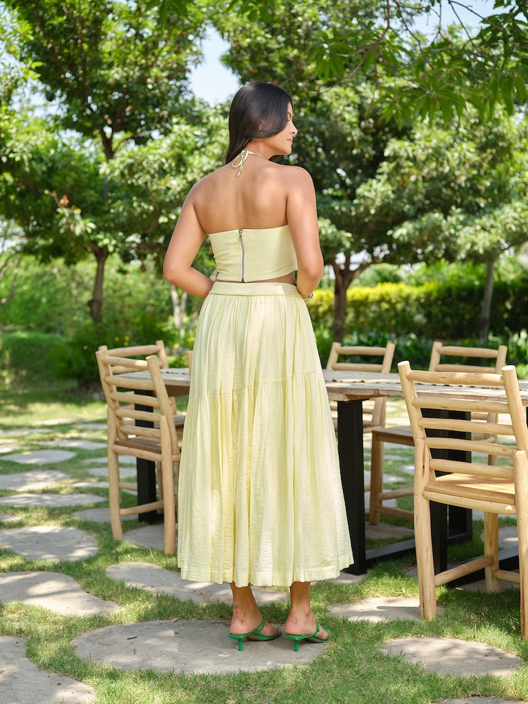 VENTORE- A yellow top adorned with intricate embroidery, enhanced with corset-style detailing for a structured fit. Paired with a layered gathered skirt