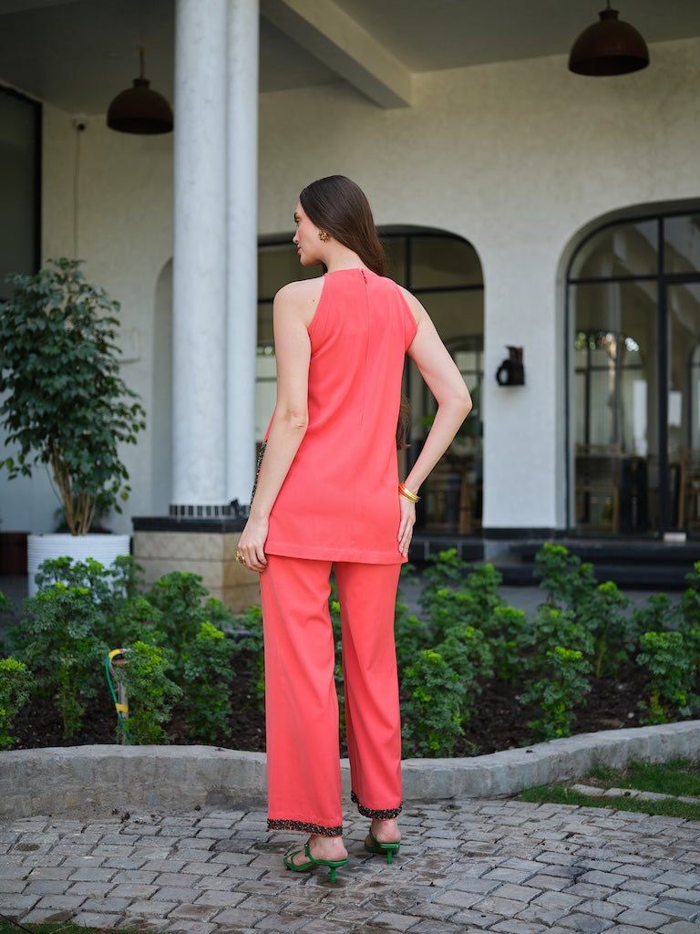 SOLARA - An orange handembroidered  deepcut top with 3D floral detail  Paired with straight pants
