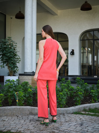 SOLARA - An orange handembroidered  deepcut top with 3D floral detail  Paired with straight pants