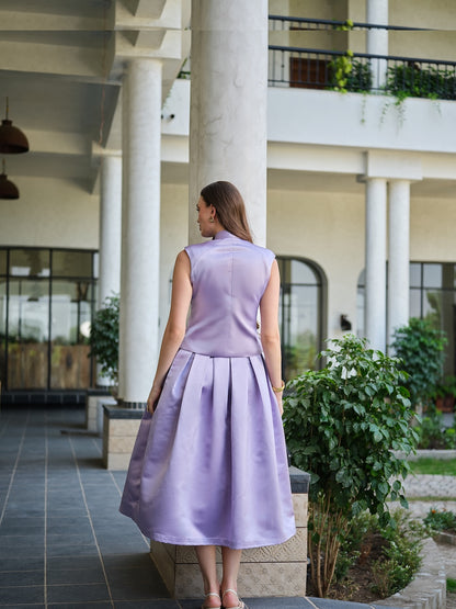 VIRELLE- A lavender sleeveless jacket with metal floral buttons paired with a box pleat skirt.