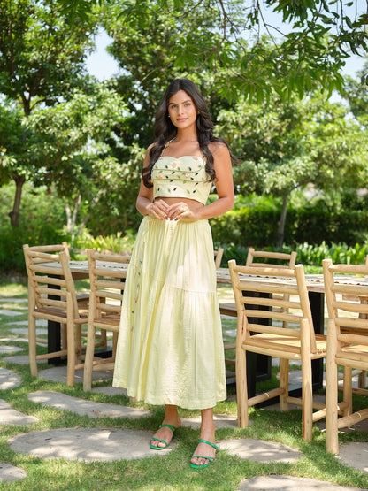 VENTORE- A yellow top adorned with intricate embroidery, enhanced with corset-style detailing for a structured fit. Paired with a layered gathered skirt