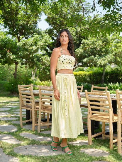 VENTORE- A yellow top adorned with intricate embroidery, enhanced with corset-style detailing for a structured fit. Paired with a layered gathered skirt