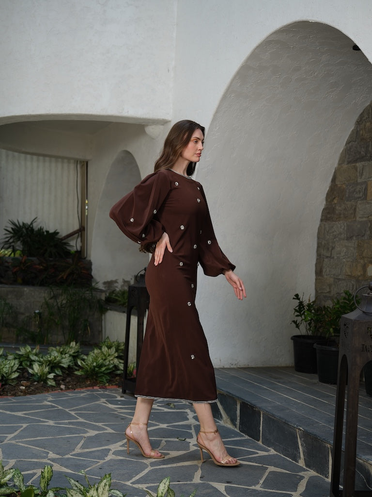 ORLANCE - A long brown dress with balloon sleeves and all-over stone scatter detailing.