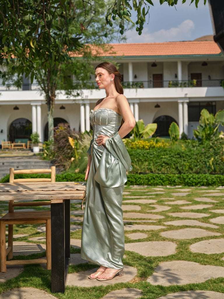 SIENNA GRACE - A mint green corset with stone, pearl, and pleated detailing paired with a draped skirt.