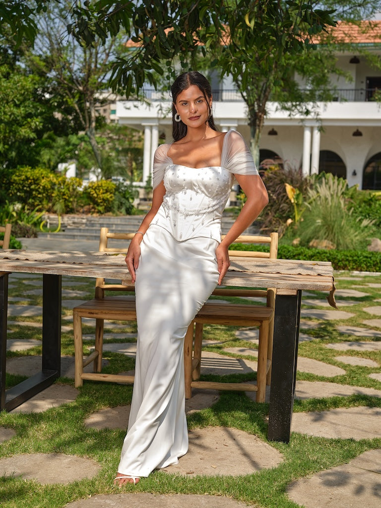 NAYORA - A white structured corset with ruched net back and latkan detailing paired with a fish-cut skirt.