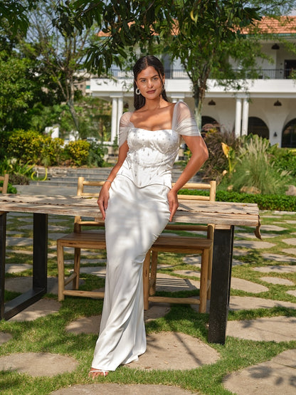 NAYORA - A white structured corset with ruched net back and latkan detailing paired with a fish-cut skirt.