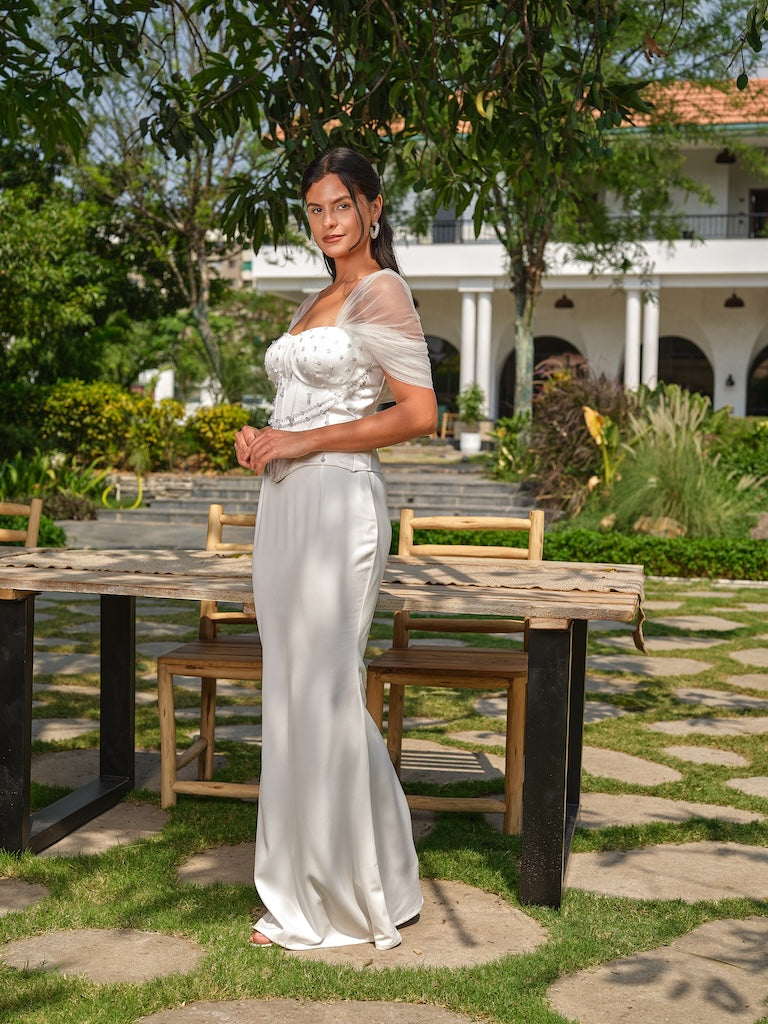 NAYORA - A white structured corset with ruched net back and latkan detailing paired with a fish-cut skirt.