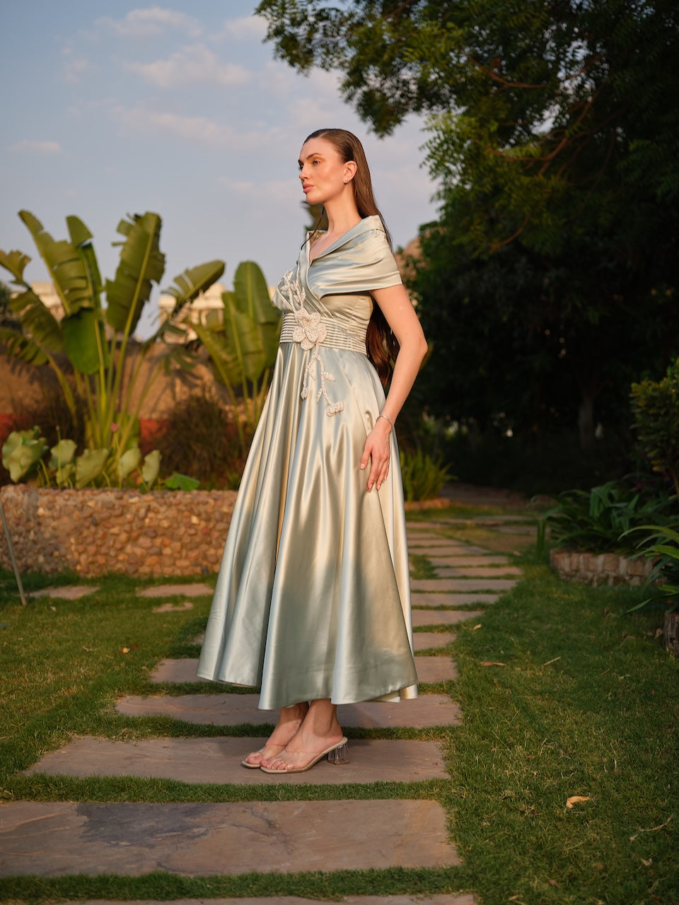 CAMELLIA -A mint green tea-length dress with elegant pleating at the waist and a halterneck with a soft flap detail.