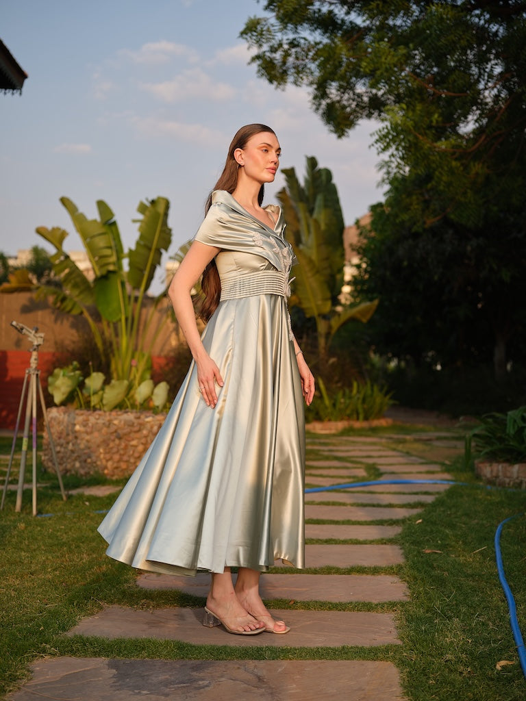 CAMELLIA -A mint green tea-length dress with elegant pleating at the waist and a halterneck with a soft flap detail.