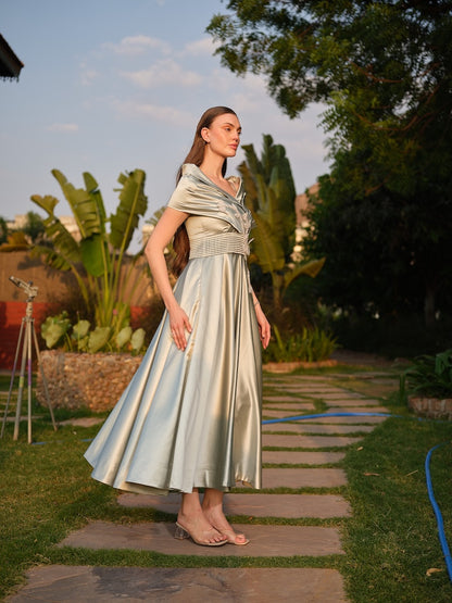 CAMELLIA -A mint green tea-length dress with elegant pleating at the waist and a halterneck with a soft flap detail.
