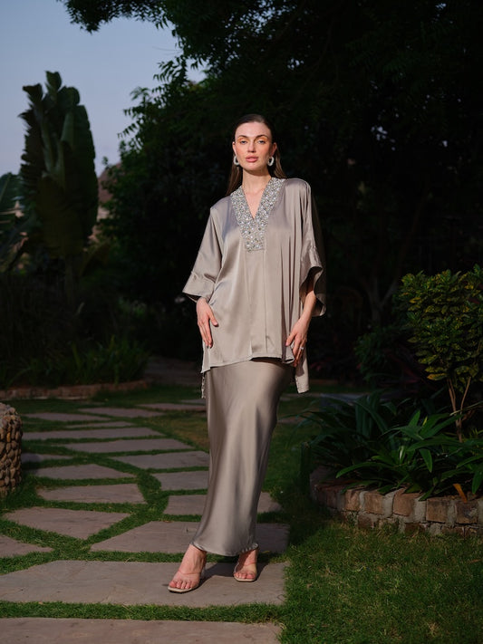 VIOLAINE - A green kaftan top featuring intricate detailing along the neckline. Paired with a sleek straight satin skirt