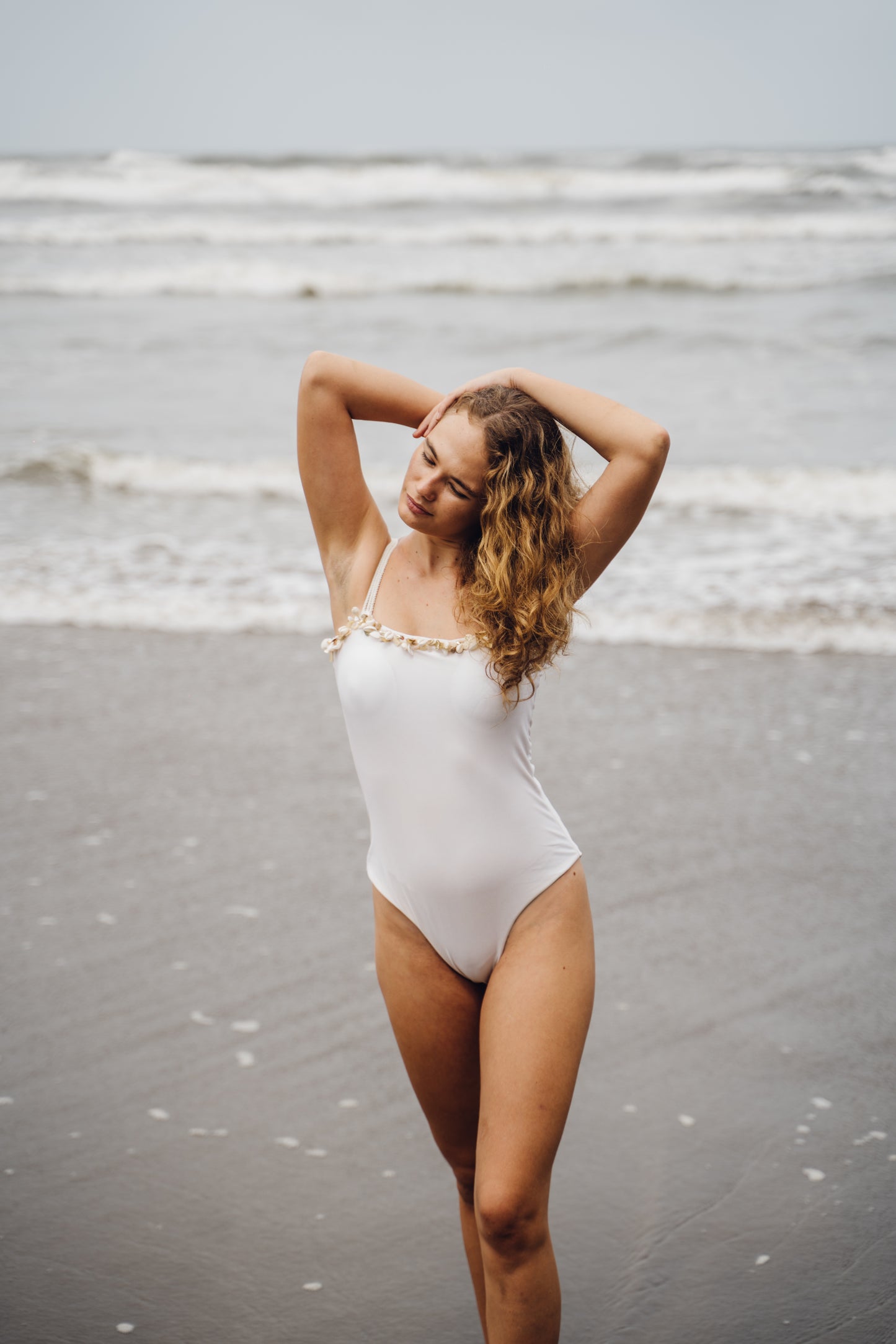 SHELLIN - Ivory bodysuit adorned with cowrie shell embroidery on the neckline and straps, finished with a rope belt