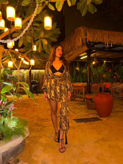 RAYA - A cheetah-print dress with a cowl neckline, tie-up waist, and fringe detailing. Paired with a worked bikini .