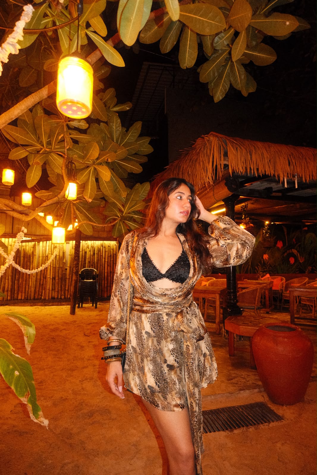 RAYA - A cheetah-print dress with a cowl neckline, tie-up waist, and fringe detailing. Paired with a worked bikini .
